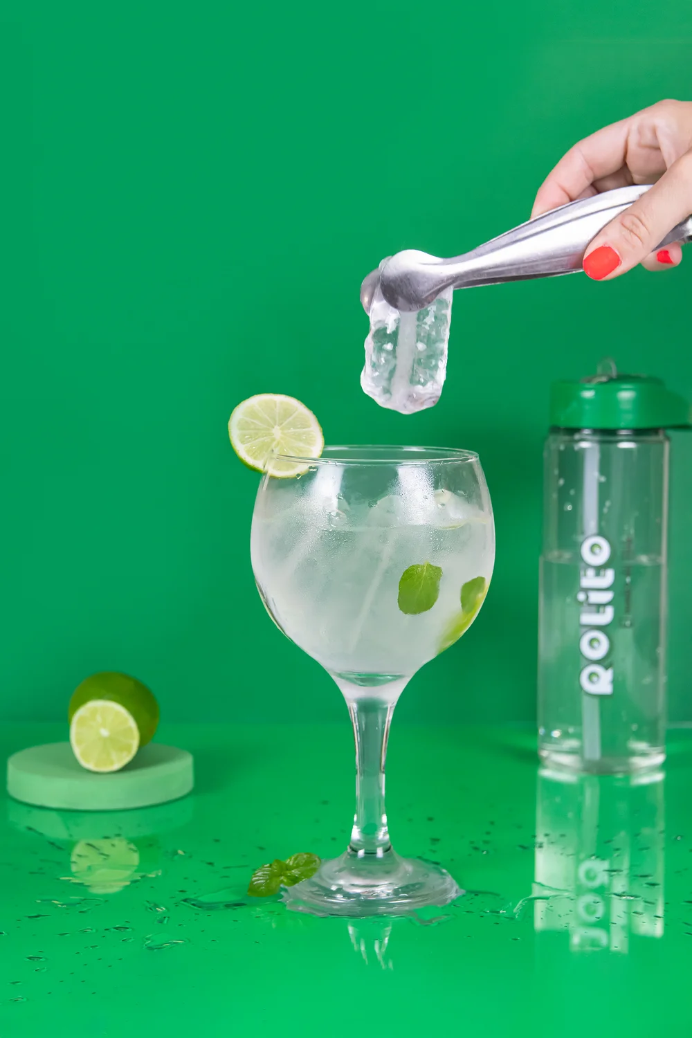 Hielo Rolito servido con pinza en copa con lima y menta
